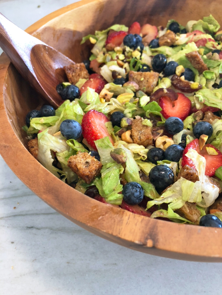 PB&J Salad with fresh blueberries, strawberries, dates, chopped pistachios, cashews, and peanut dressing.